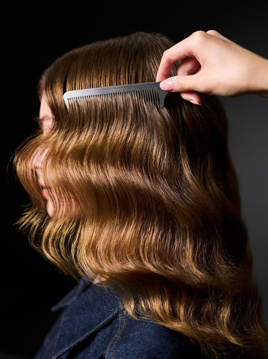Woman with sleek waves having her hair combed