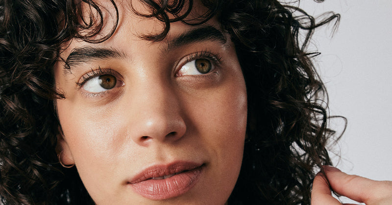 Curly-haired woman feeling her hair