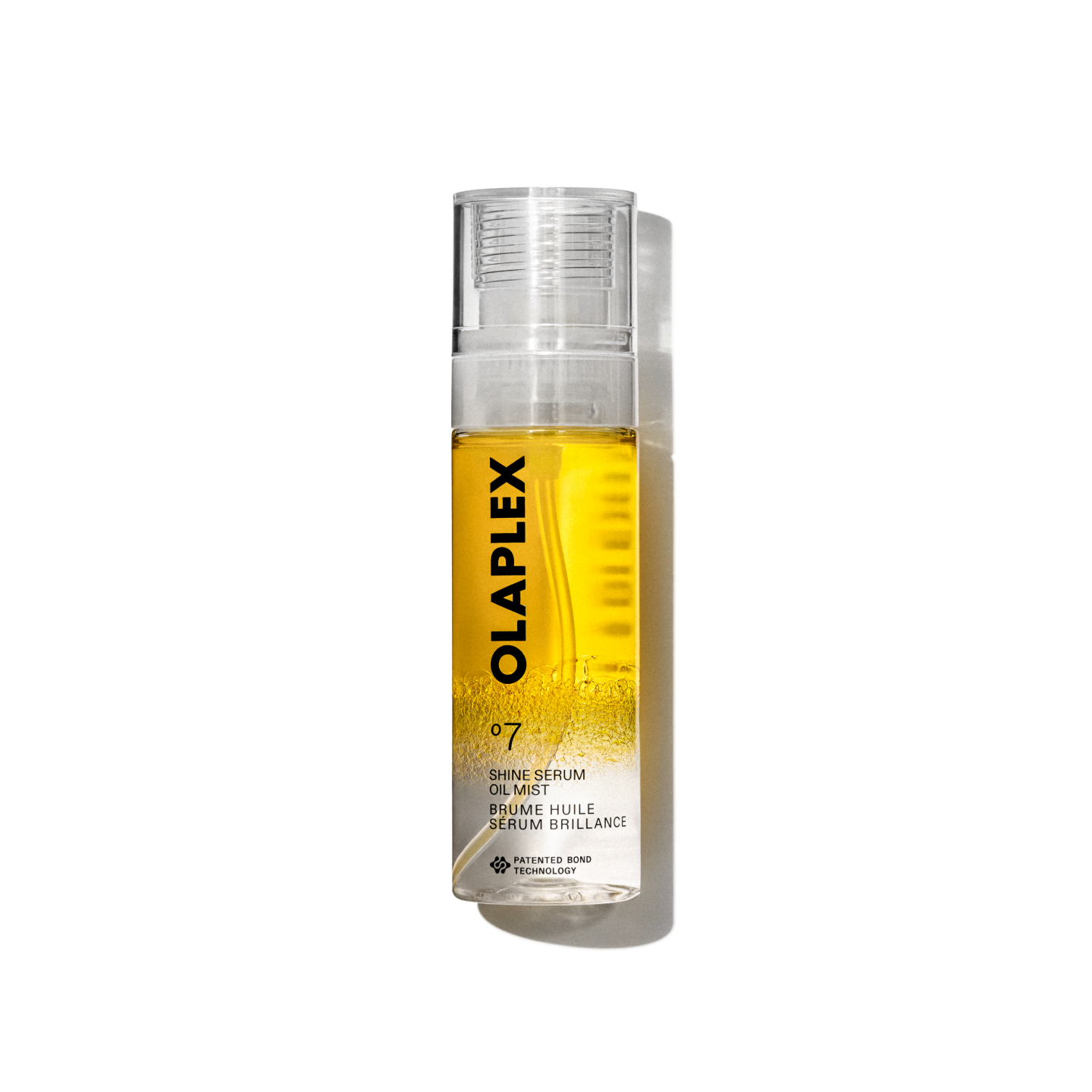 Imagen de producto del Olaplex No. 7 Shine Serum Oil Mist en un pulverizador transparente de 80 ml. La botella contiene un líquido amarillo brillante visible en su interior, una tapa transparente y una etiqueta blanca limpia en la parte inferior con texto negro que muestra el nombre del producto, los detalles y la firma “No.” Logotipo de 7". La botella aparece aislada sobre un fondo de cuadrícula transparente.