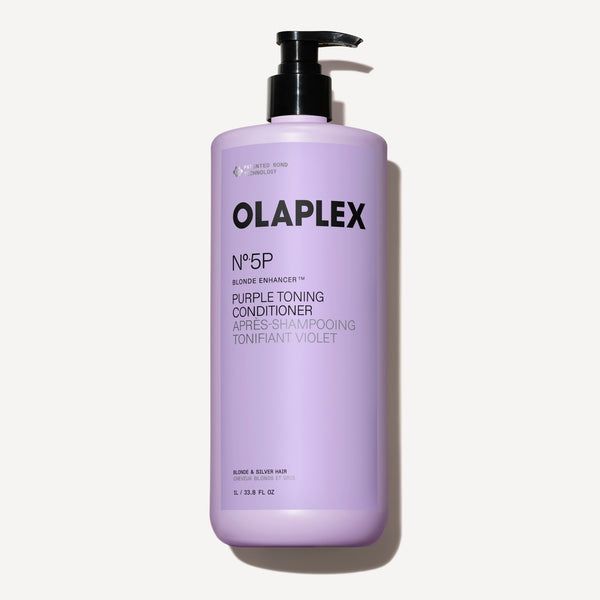 A one-liter bottle of Olaplex No. 5P Purple Toning Conditioner with a black pump dispenser, centered against a dark checkered background. - main view